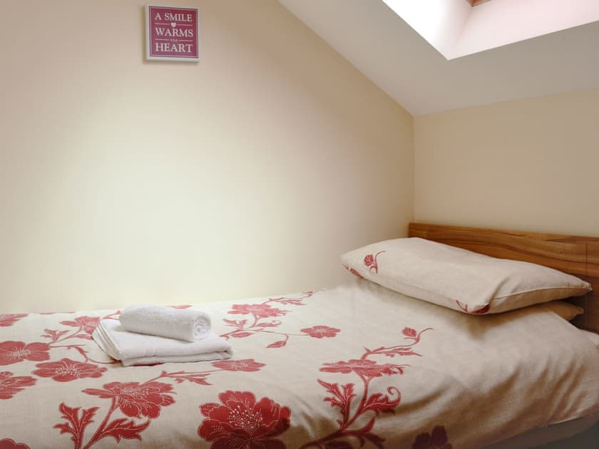 The comfortable twin bedroom has sloping ceilings | Ysgubor Uchaf - Bwlchgwyn Equestrian Holidays, Arthog, near Fairbourne