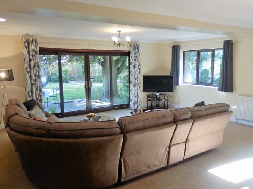 Spacious living room with patio doors to garden | The Beech House, Corton, near Lowestoft