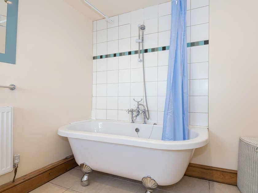 Bathroom featuring standalone bath with shower | Lazy Cottage, Haverigg, near Millom