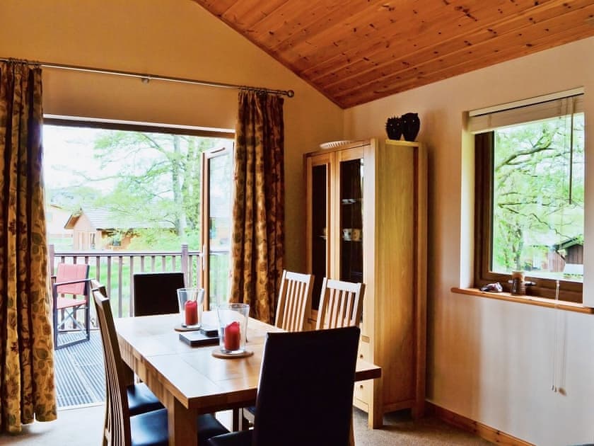 The dining table is next to a set of patio doors that open onto the terrace | Rowanburn Lodge, Greystoke, near Penrith