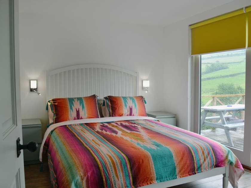 Comfortable double bedroom with doors leading to patio  | The Shed with a View, Cadbury, near Crediton