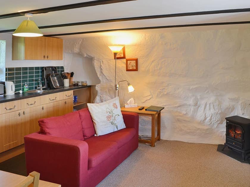 Whitewashed stone walls and comfortable furniture in the open plan living space | The Hayloft Barn - Tyddyn Iolyn, near Criccieth
