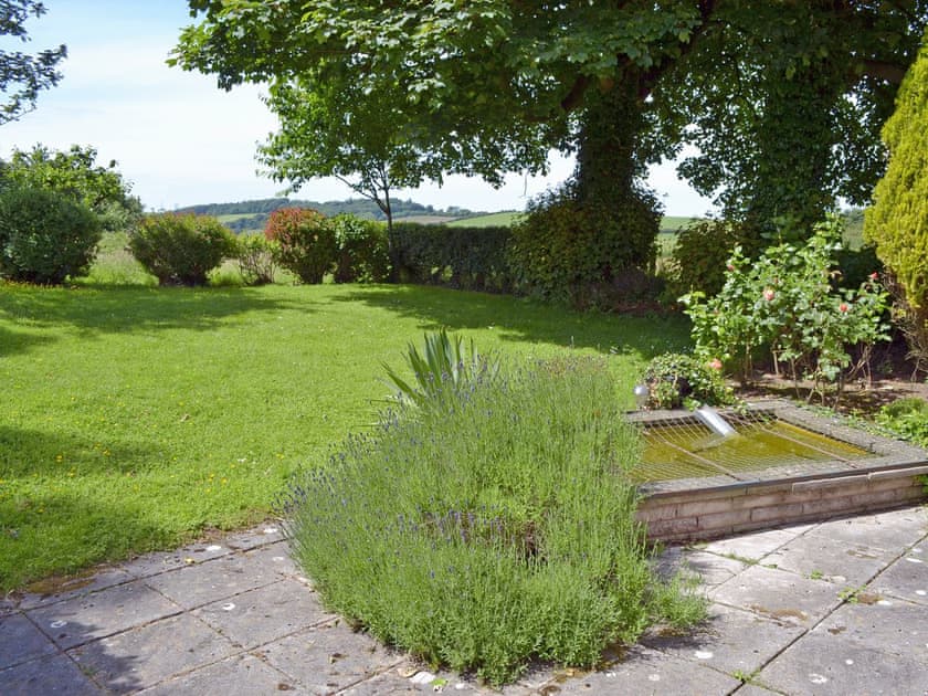 Enclosed lawned garden with patio | Pant Glas Mawr Cottage, Axton, near Holywell
