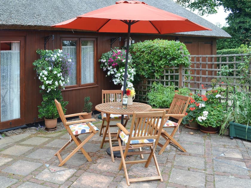 The paved area has a table and chairs for alfresco dining options | Church Farm Studio, Surlingham