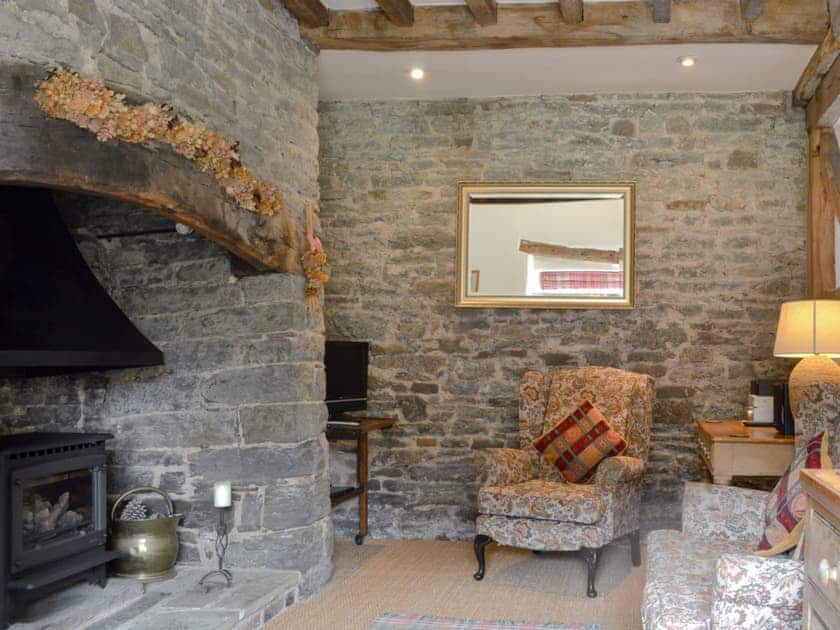 Living room with oak beams throughout and large inglenook fireplace | The Bothy, Clun, near Craven Arms
