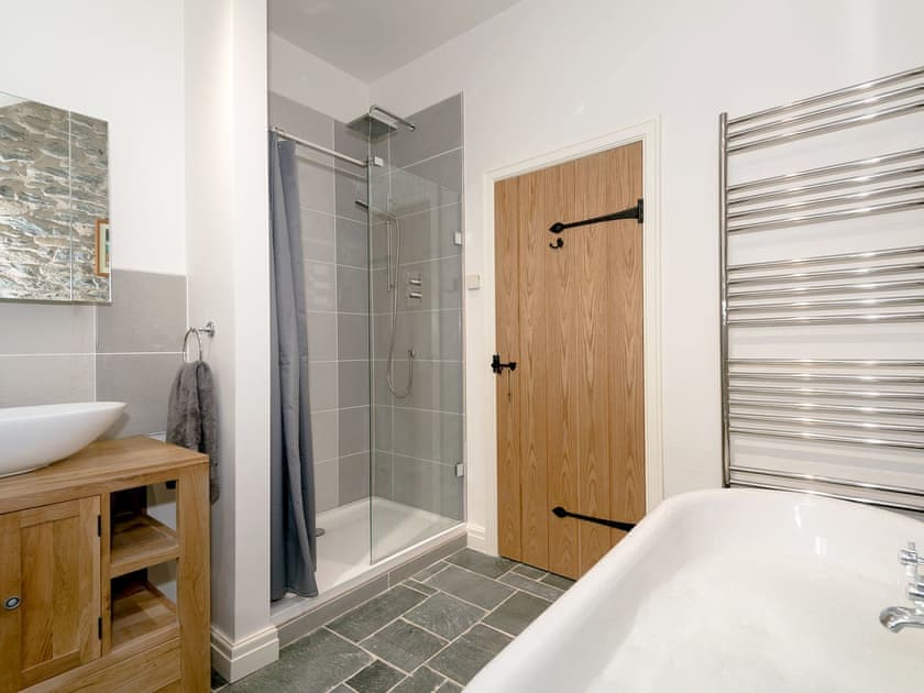 Bathroom with roll-top bath, shower cubicle and toilet | Waterfall Wood Cottage, Glenridding, by Ullswater