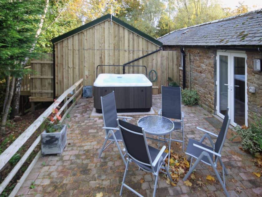 The patio makes a great place to sit out or enjoy a relaxing session in the Jaccuzi | Nuthatch Cottage - Wallace Lane Farm Cottages, Brocklebank, near Caldbeck and Uldale