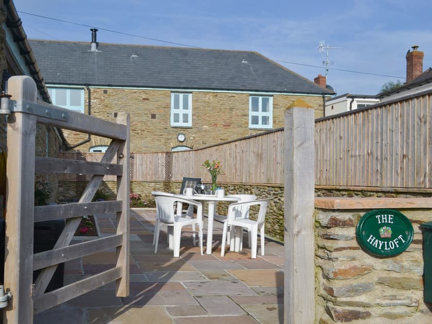 Enclosed courtyard garden with sitting-out area and garden furniture | The Hayloft, East Charleton, near Kingsbridge