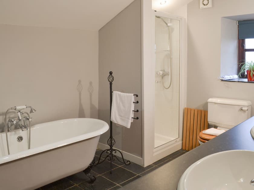 Roll-top bath and separate shower cubicle in bathroom | The Stables - Tyddyn Iolyn, near Criccieth