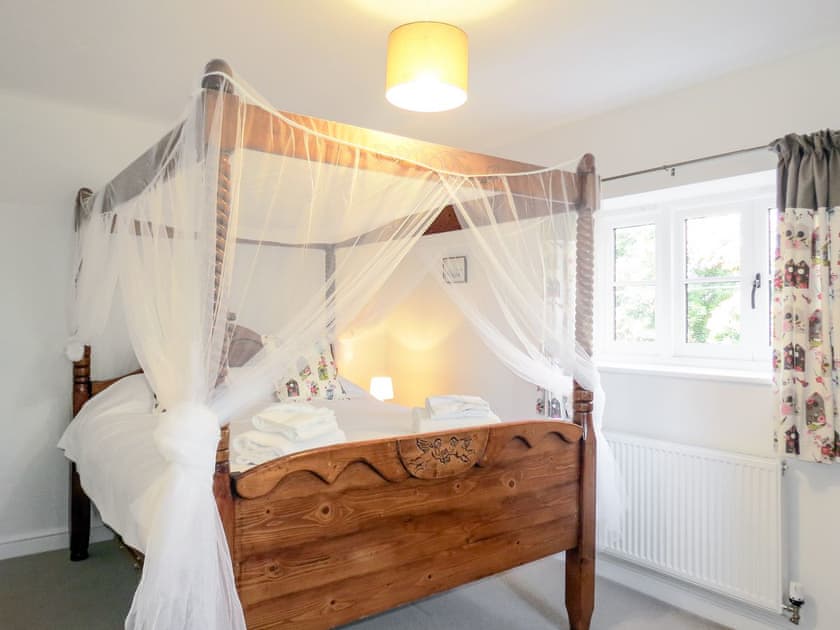Master bedroom with four poster kingsize bed | Roseanna Cottage, Middleton, near Leiston