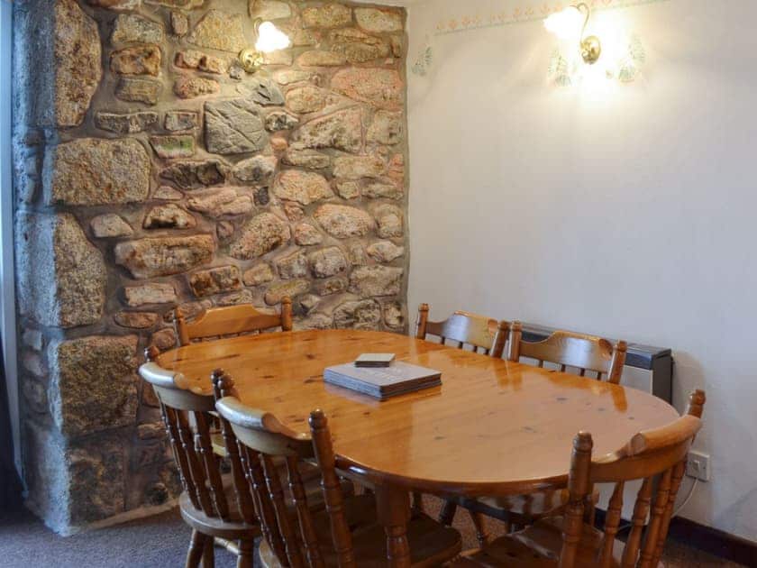 Dining area with exposed stone wall | Stable Cottage, Gulval, near Penzance