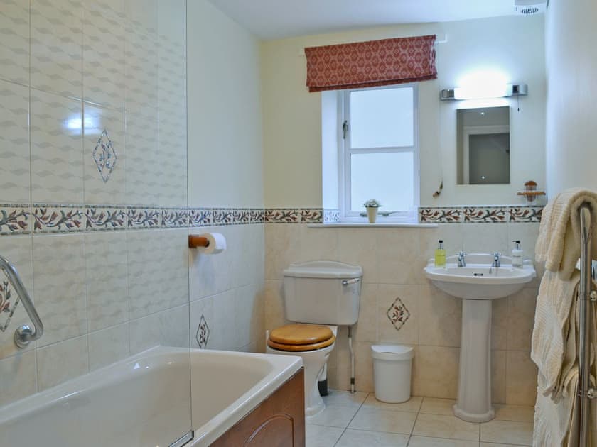 Bathroom with shower over bath | The Arches - Home Farm Holiday Cottages, Slingsby, near Malton