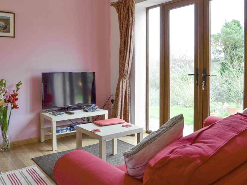 Cosy living room with double doors to patio | Spindlestone - Wide Sky Cottages, Lowick, near Berwick-on-Tweed