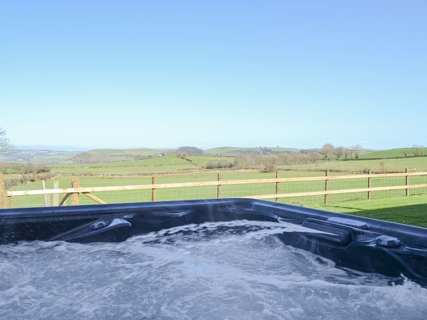 Soak up the glorious Welsh sunshine whilst relaxing in the hot tub | Bryncrwn Cottage, Llanfarian, Aberystwyth