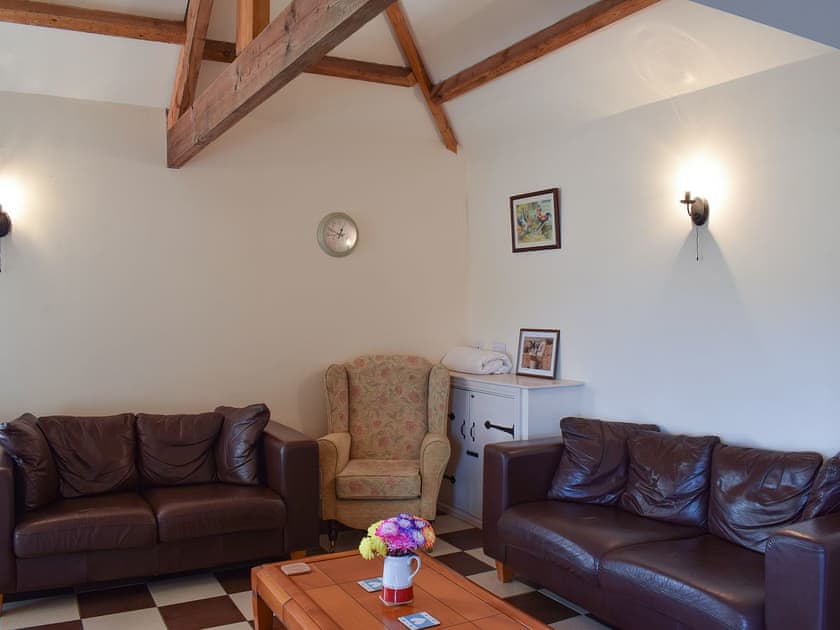 Beamed living area with stylish leather sofas | Betty’s Byre - Cleveland View Cottages, Easby Grange, near Great Ayton
