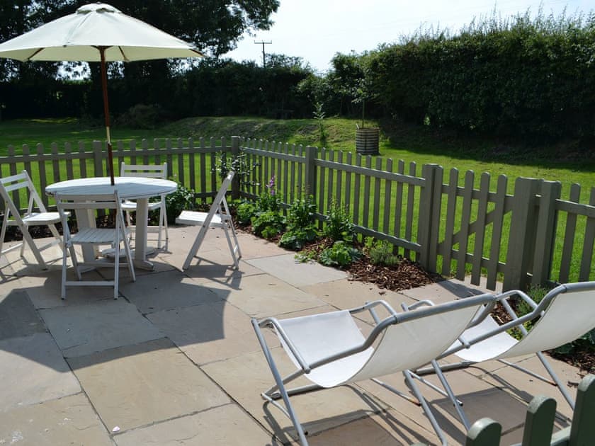 Patio area and view over lawned garden | The Boat House, Roughton, near Cromer