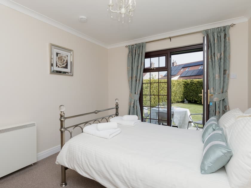 Double bedroom with French doors leading to the garden | Cleet’s Retreat, Seahouses