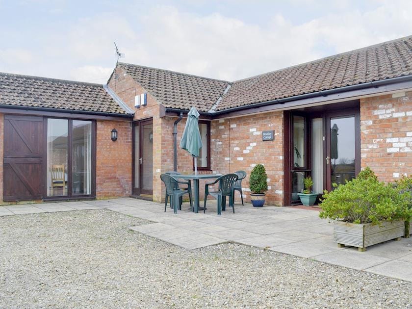 Attractive holiday home with outdoor furniture on a paved patio | Bramley Cottage, Lympsham, near Weston-super-Mare