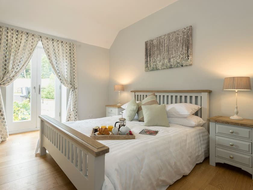Elegantly decorated double bedroom with doors leading to patio | The Stables, Aisby, near Grantham