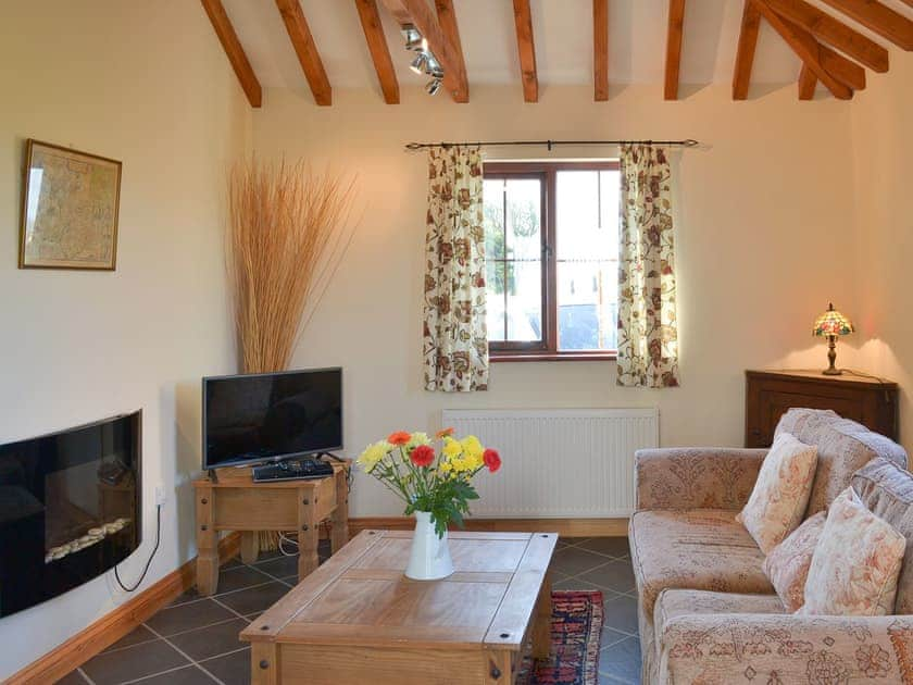 Beamed living room with contemporary electric fire | Beckaveans Stable - Beckaveans, Jacobstow, near Bude