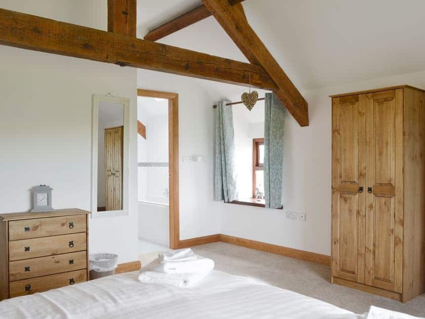Exposed wood beams in double bedroom | Llofft Storws - Bronallt Barns, Llanynghenedl, near Holyhead