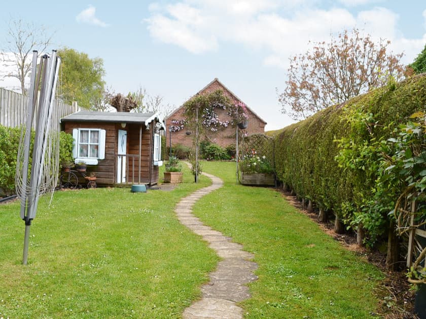 Lawned garden with playhouse | Ringstead Cottage, Ringstead, near Hunstanton