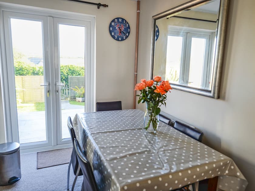 Inviting dining area with French doors leading to garden | The Yellow House, Padstow