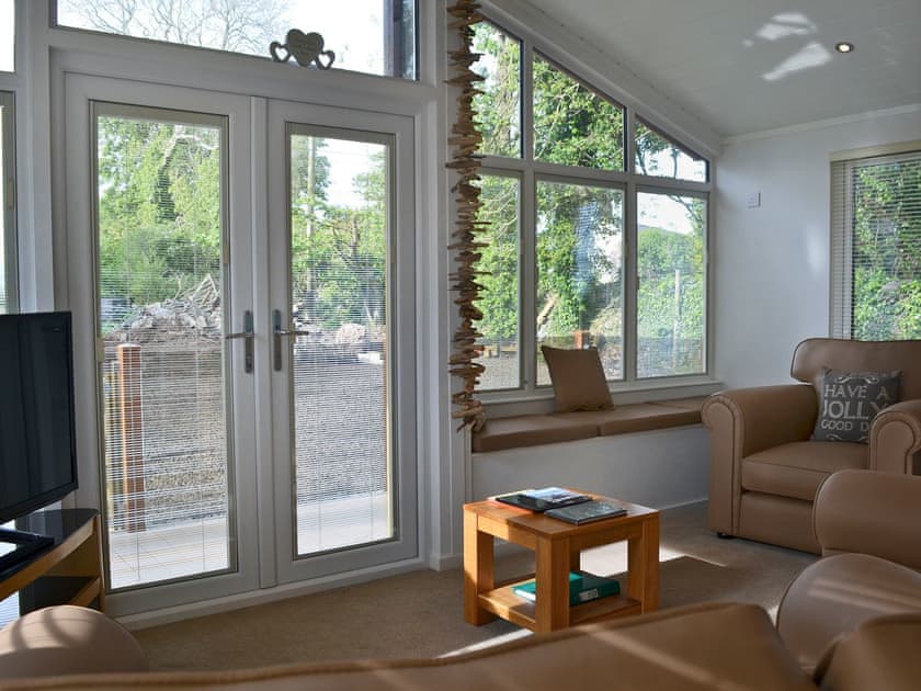 Cosy living room area with patio doors | Ysgubor FadogEin Yfory, Brynteg, near Benllech