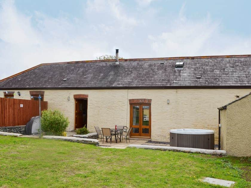 Patio with garden furniture and private hot tub | Yr Hen Feudy - Bronallt Barns, Llanynghenedl, near Holyhead