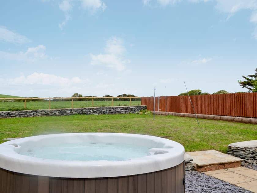 Enclosed lawned garden with patio, garden furniture and private hot tub. | Yr Hen Feudy - Bronallt Barns, Llanynghenedl, near Holyhead