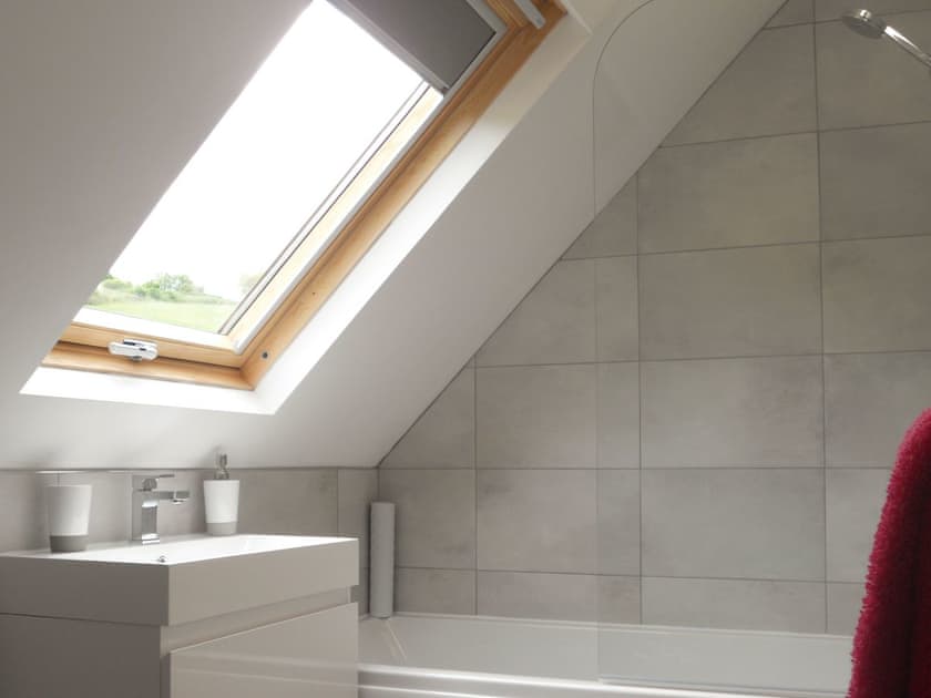 Light and airy en-suite bathroom with shower over bath | The Cob Barn - Longmeadow Farm, Shaldon, near Teignmouth