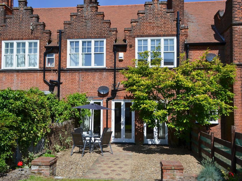 Enclosed lawned garden with sitting-out area and garden furniture | Magnolia Lodge, Sheringham