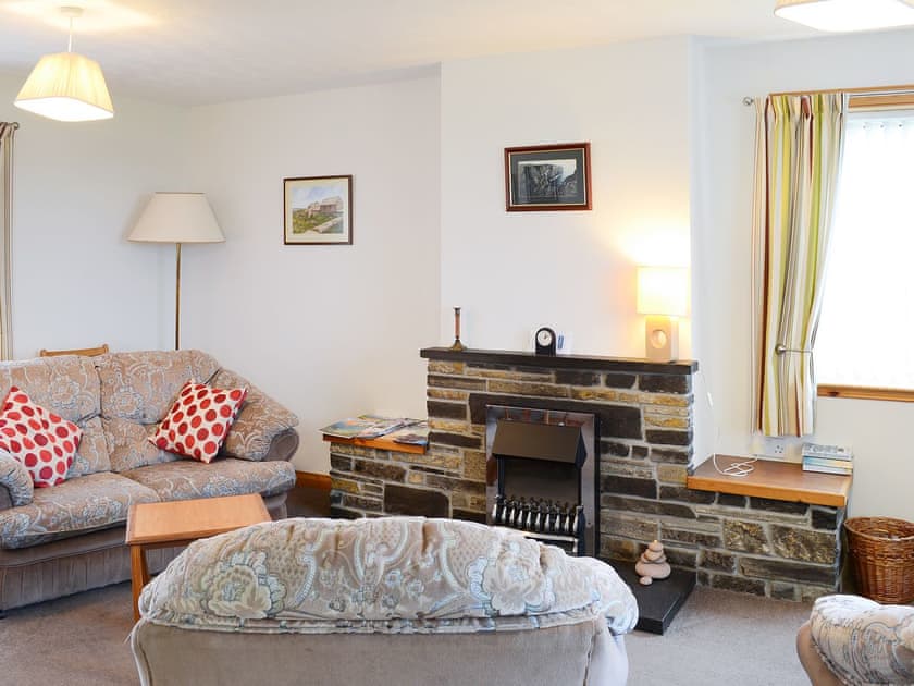 Living area with comfortable furniture and feature fireplace | John O’ Groats - Horseman’s Cottage - Watermill Cottages, John O’ Groats