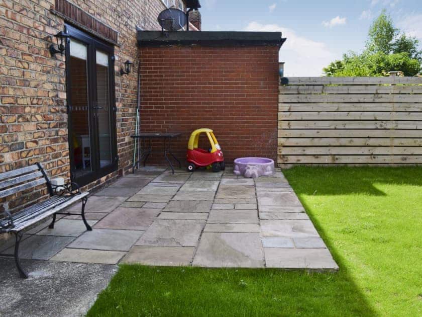 Enclosed lawned garden with patio and garden furniture | Apple Tree House, Scarborough