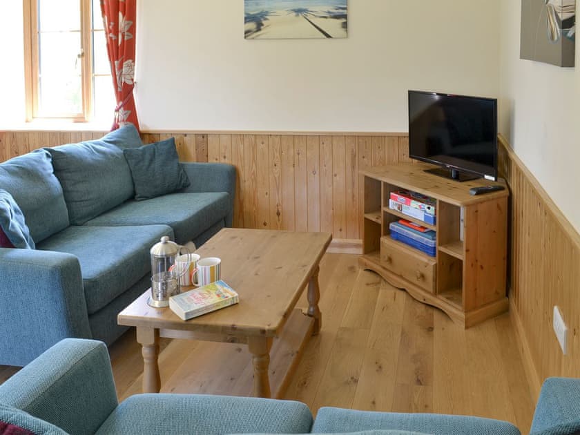 Cosy seating area | Tarka’s Holt Log Cabin - Stowford Lodge Holiday Cottages, Langtree, near Great Torrington