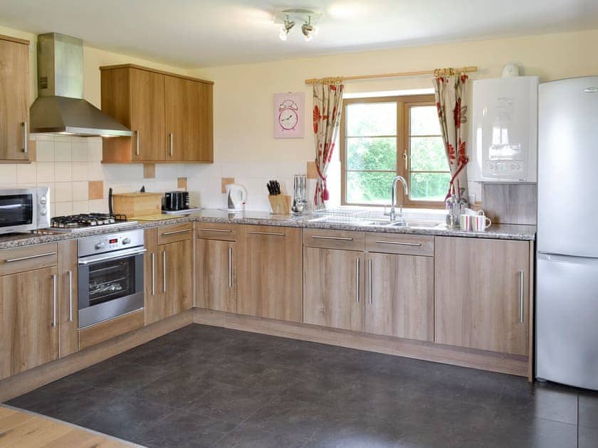 Fully-appointed fitted kitchen area | Tarka’s Holt Log Cabin - Stowford Lodge Holiday Cottages, Langtree, near Great Torrington
