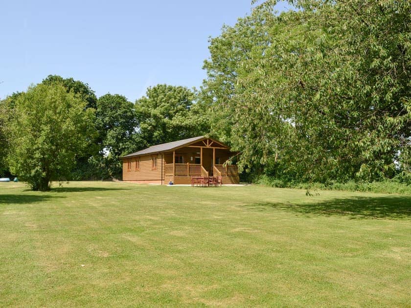 Lodge style holiday home with large lawned garden | Tarka’s Holt Log Cabin - Stowford Lodge Holiday Cottages, Langtree, near Great Torrington