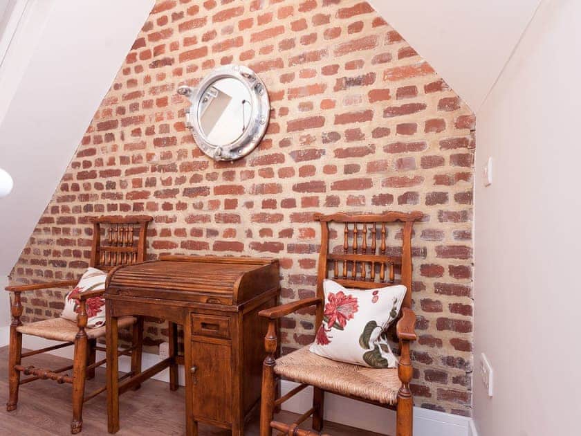 Landing with exposed brickwork and peaceful sitting area | Bank Apartment 2, Dartmouth