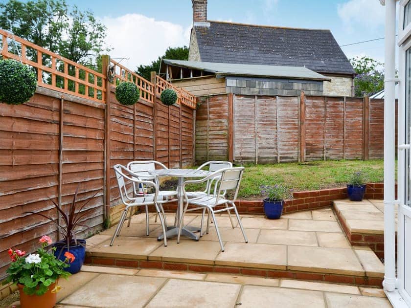 Enclosed lawned garden with sitting-out area and garden furniture | Horseshoe Cottage, Porchfield, near Cowes
