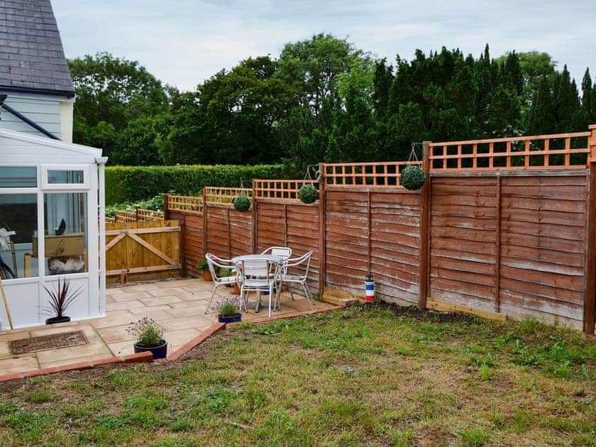Enclosed lawned garden with sitting-out area and garden furniture | Horseshoe Cottage, Porchfield, near Cowes
