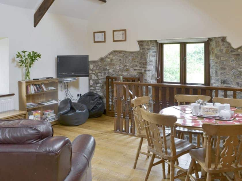 Cosy open-plan living space with wooden beams and wood floor | Homeleigh Barn - Burracott Farm, Poundstock, Bude