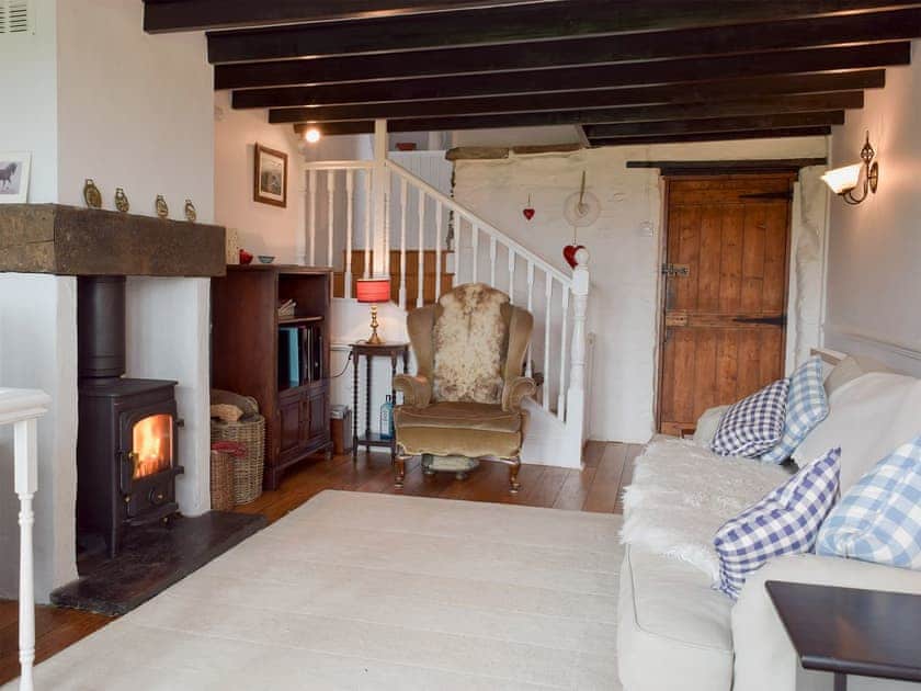 Living room with wood burner and patio doors leading to balcony | Y Teras, Rosebush, near Narberth