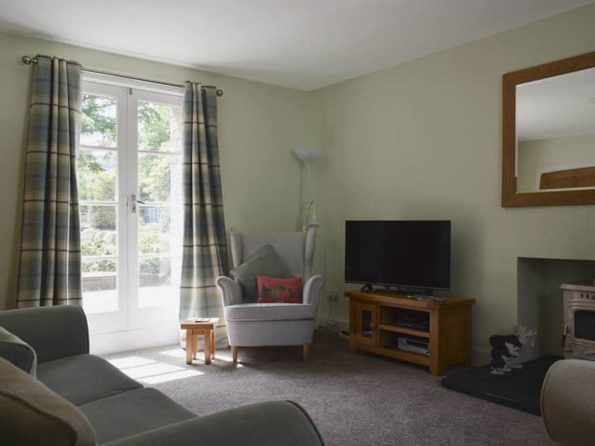 Living room with wood burner and French doors leading to patio | Toad Hall, Aberfeldy