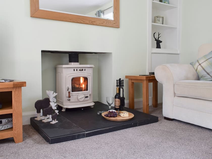Living room with wood burner and French doors leading to patio | Toad Hall, Aberfeldy