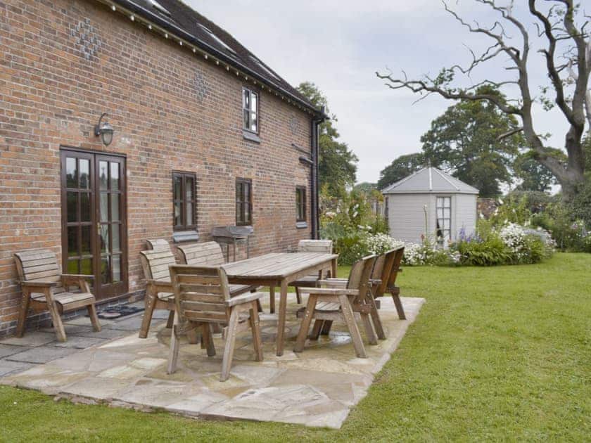 Paved patio with outdoor furniture in garden | Buddileigh Farm, Betley, near Nantwich