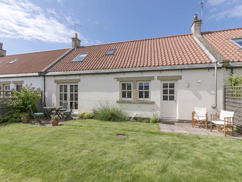 Rear garden with twin patio areas | Embleton Cottage, Beadnell