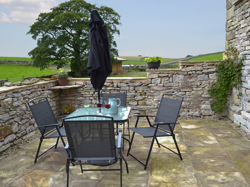 Paved patio area with table and chairs | Brow View Cottage, Ravenstonedale, near Kirkby Stephen