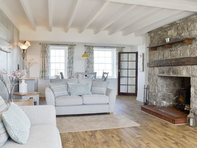 Spacious living and dining room with feature fireplace | Bwthyn Y Borth, Rhoscolyn, near Holyhead
