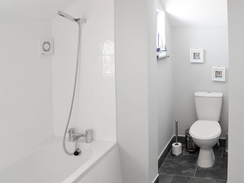 Bathroom with shower over bath, and toilet | Morvoren (Sea Maiden) Cottage, The Lizard Village, near Helston