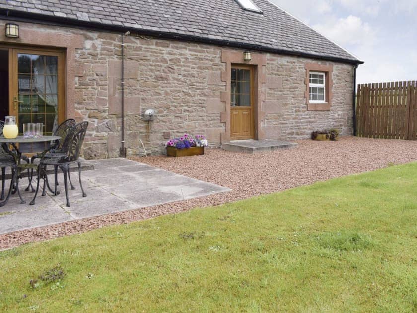 Enclosed rear garden and patio | The Stables - Loch Lomond Farm Cottages, Balfron Station, near Stirling
